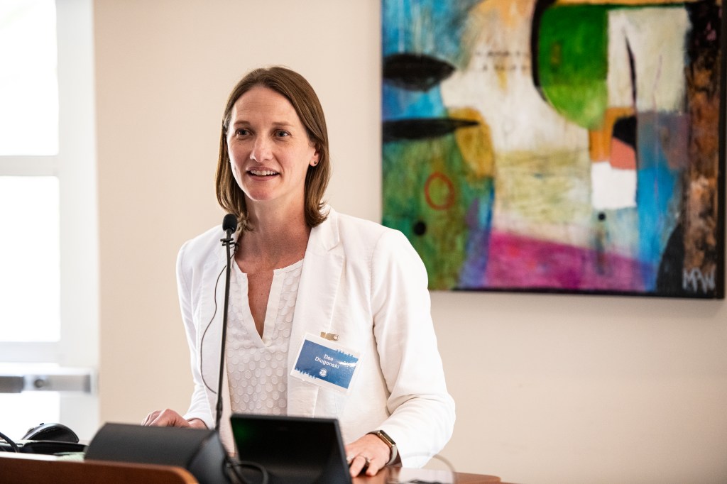 Dee Dlugonski speaking at podium